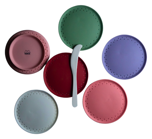 Six mini serving plates in six colours, arranged around a porcelain knife
