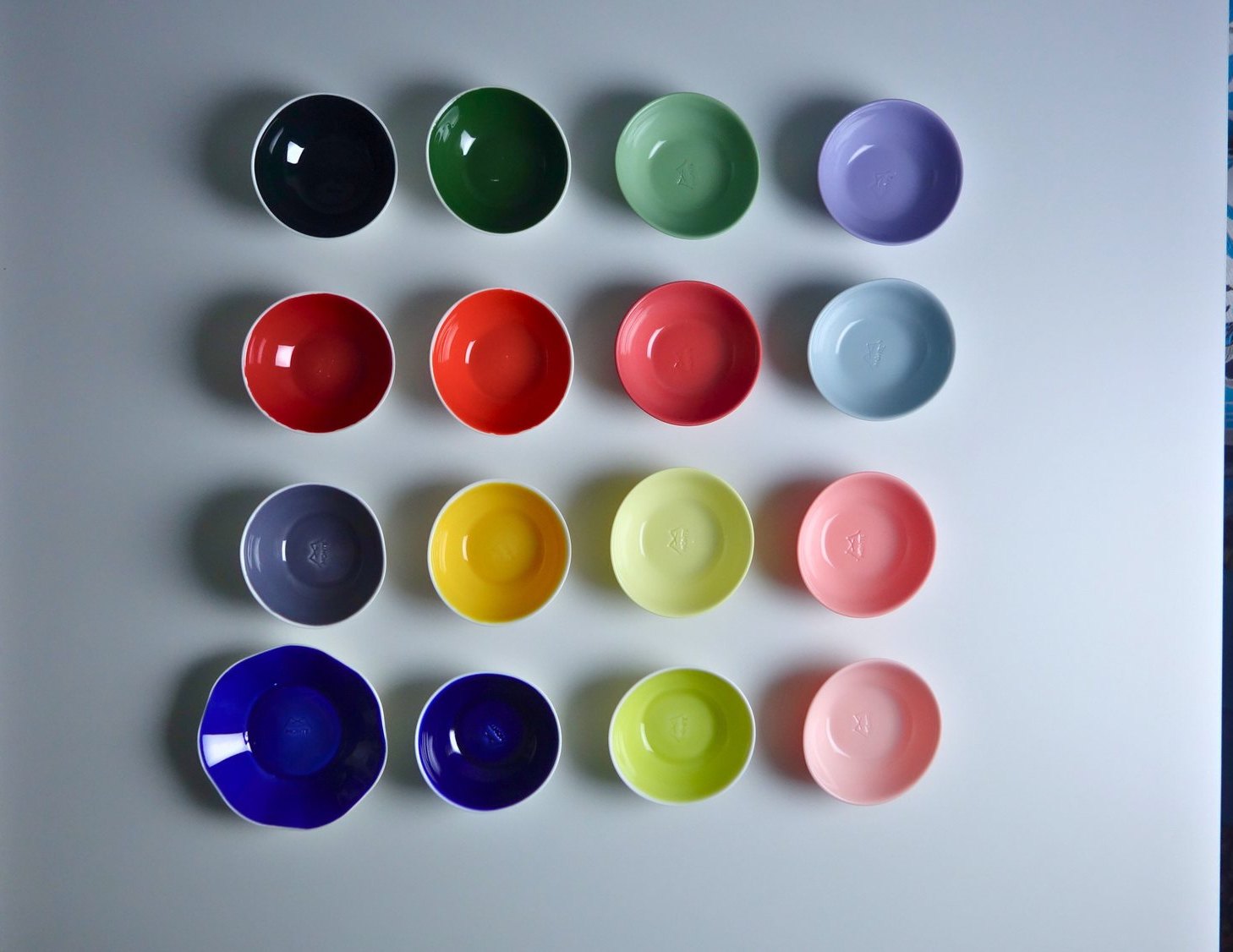 Sixteen Monte glaze colours shown on small bowls arranged in a grid
