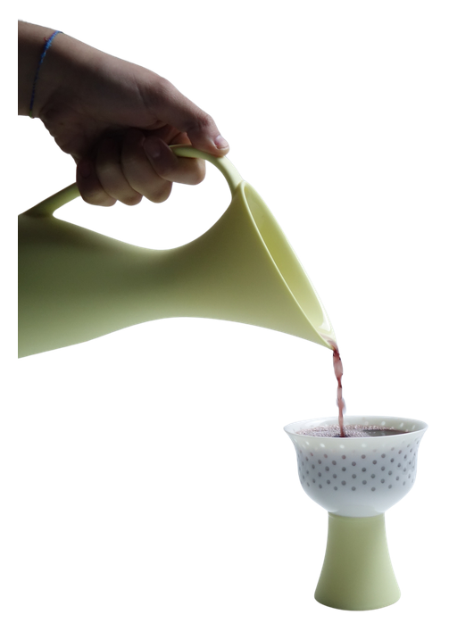 A lemon Swan Pitcher pouring into a pierced Firefly goblet